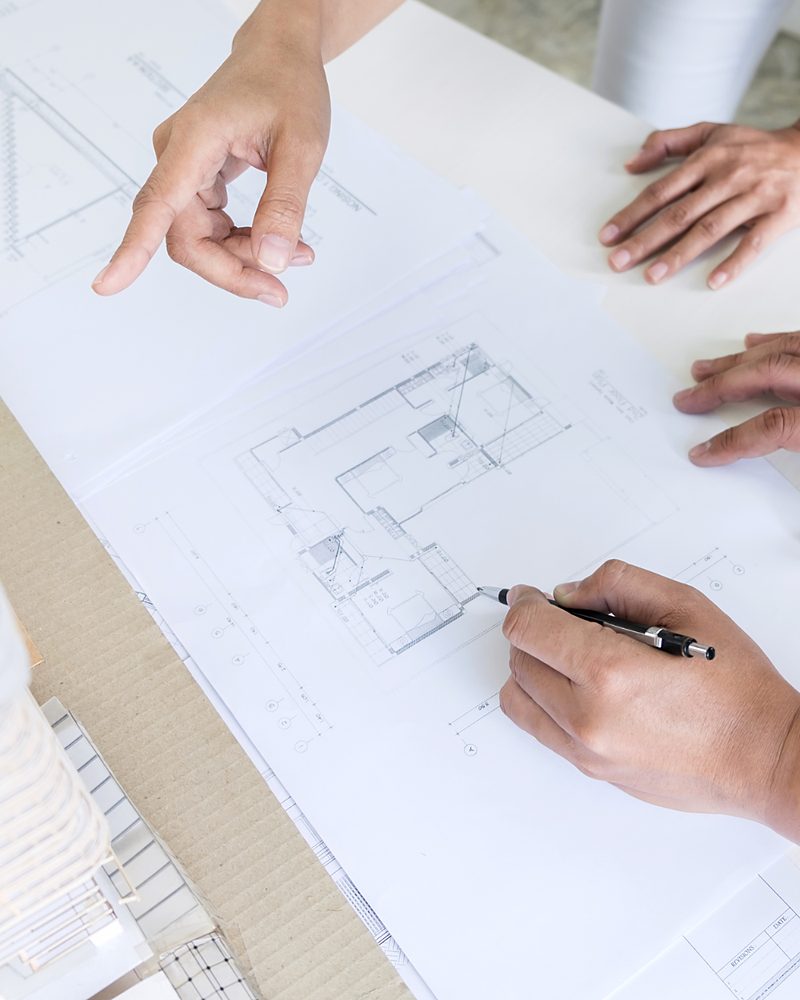 Building plans being marked up on a desk